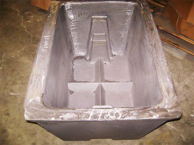 A large metal container is sitting on a concrete floor.