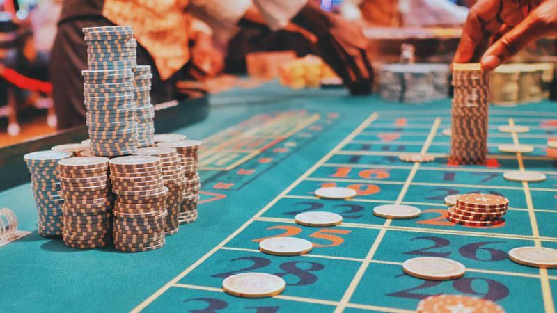 A person is playing roulette in a casino with chips on the table.