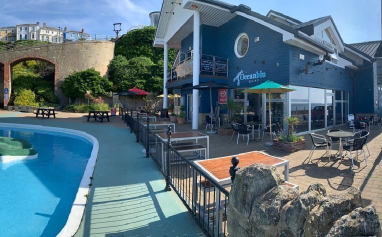 Besty & Spinky's at Ocean Quay on Ventnor Seafront showing outside tables on the terrace and the famous Ventnor paddling pool