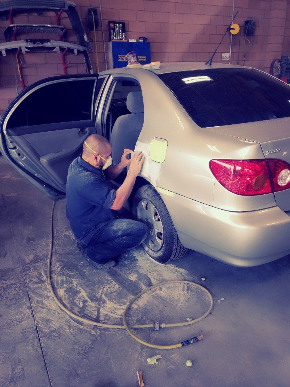 Auto Paintwork — Man Sanding The Quarter Panel of The Car in Las Vegas, NV