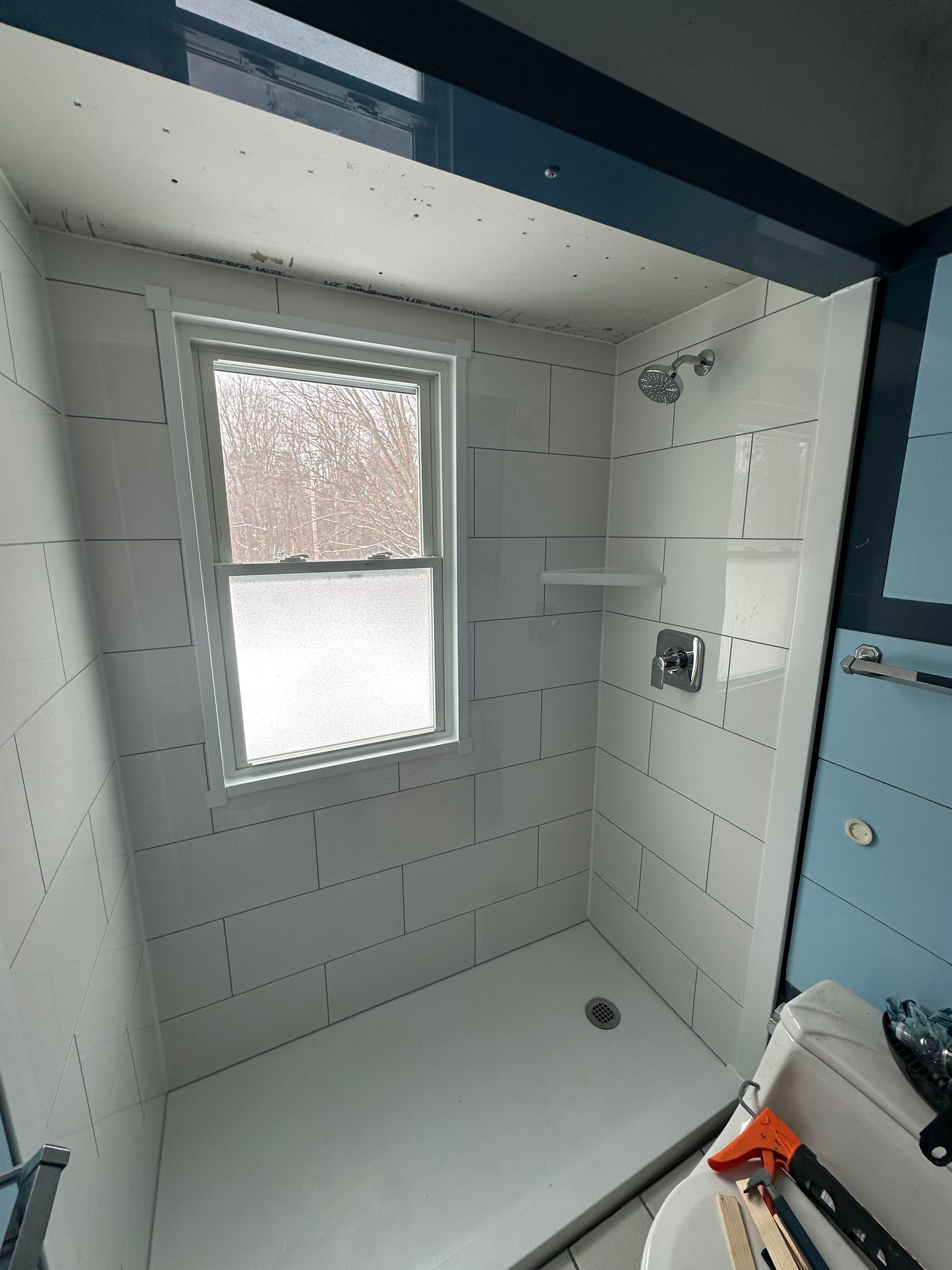 A bathroom with a shower and a window.