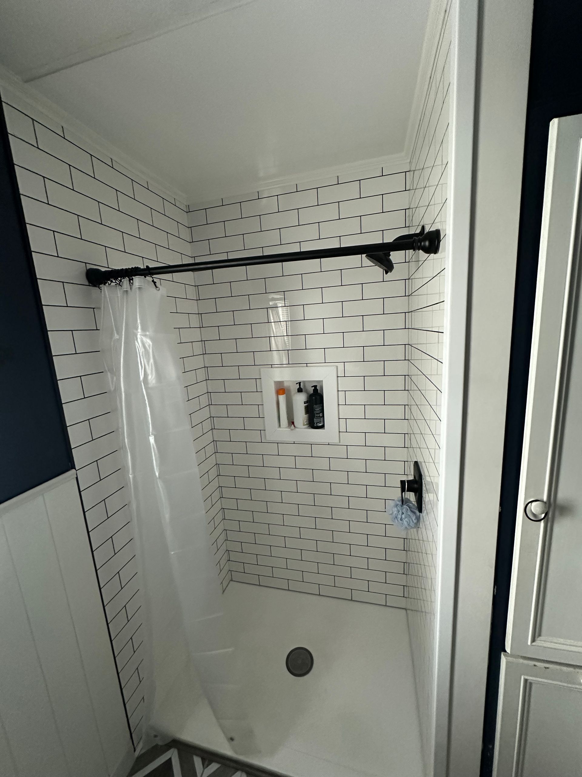 A bathroom with a shower stall and a shower curtain