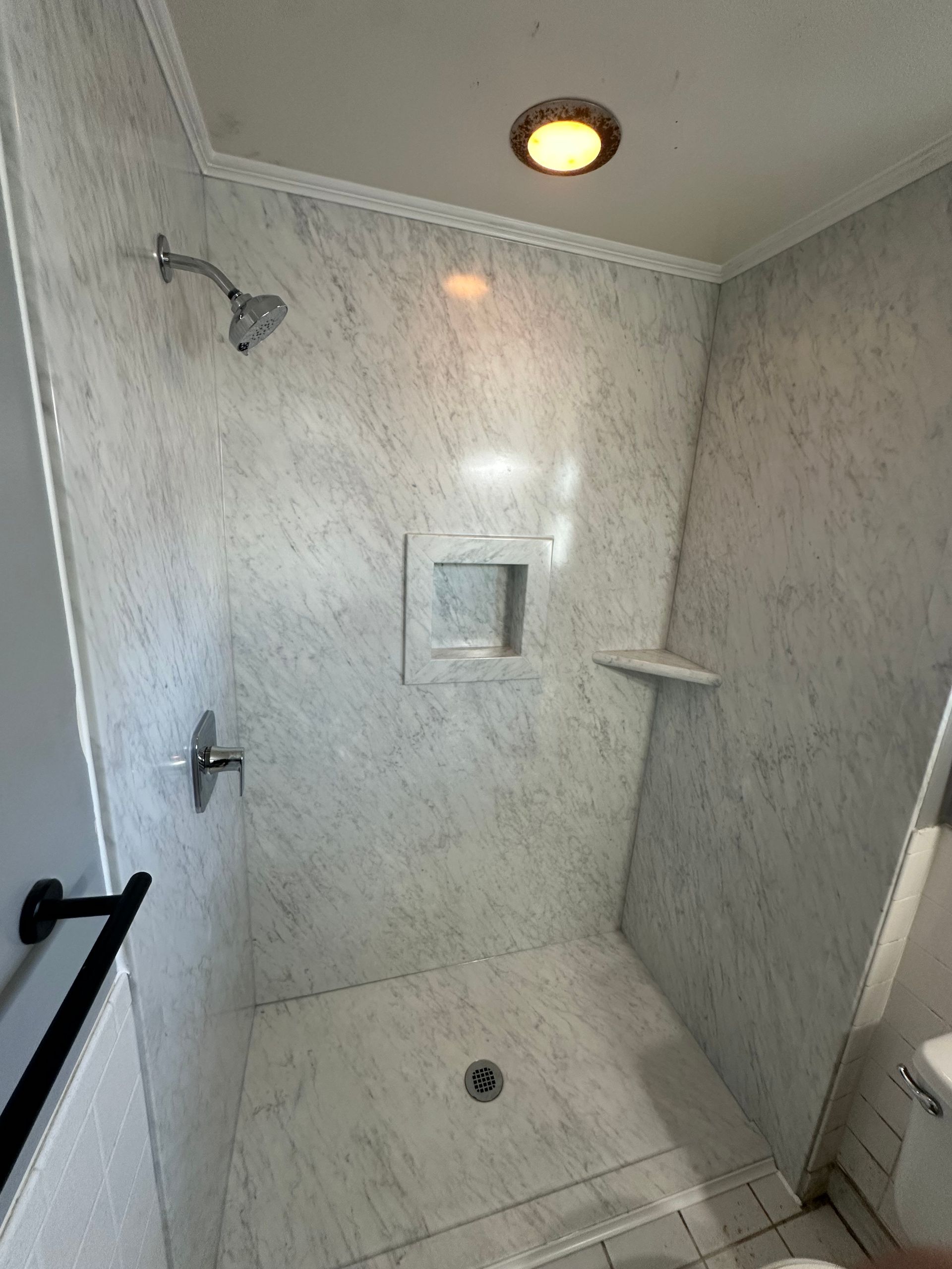 A bathroom with a walk in shower and a toilet.