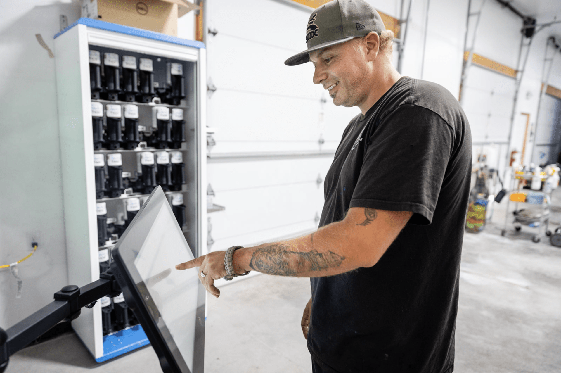 A man is looking at a computer screen in a garage.