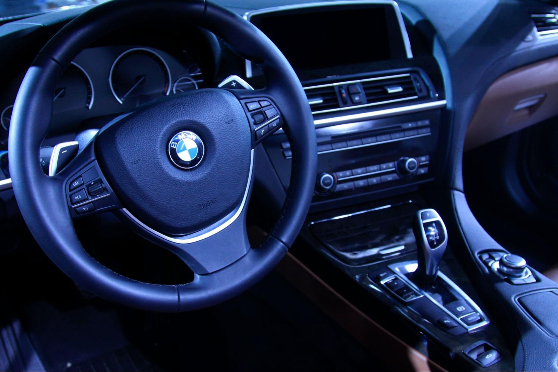 A close up of a bmw steering wheel and dashboard