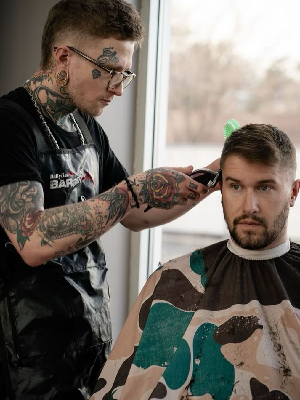 A man is getting his hair cut by a barber in a barber shop.