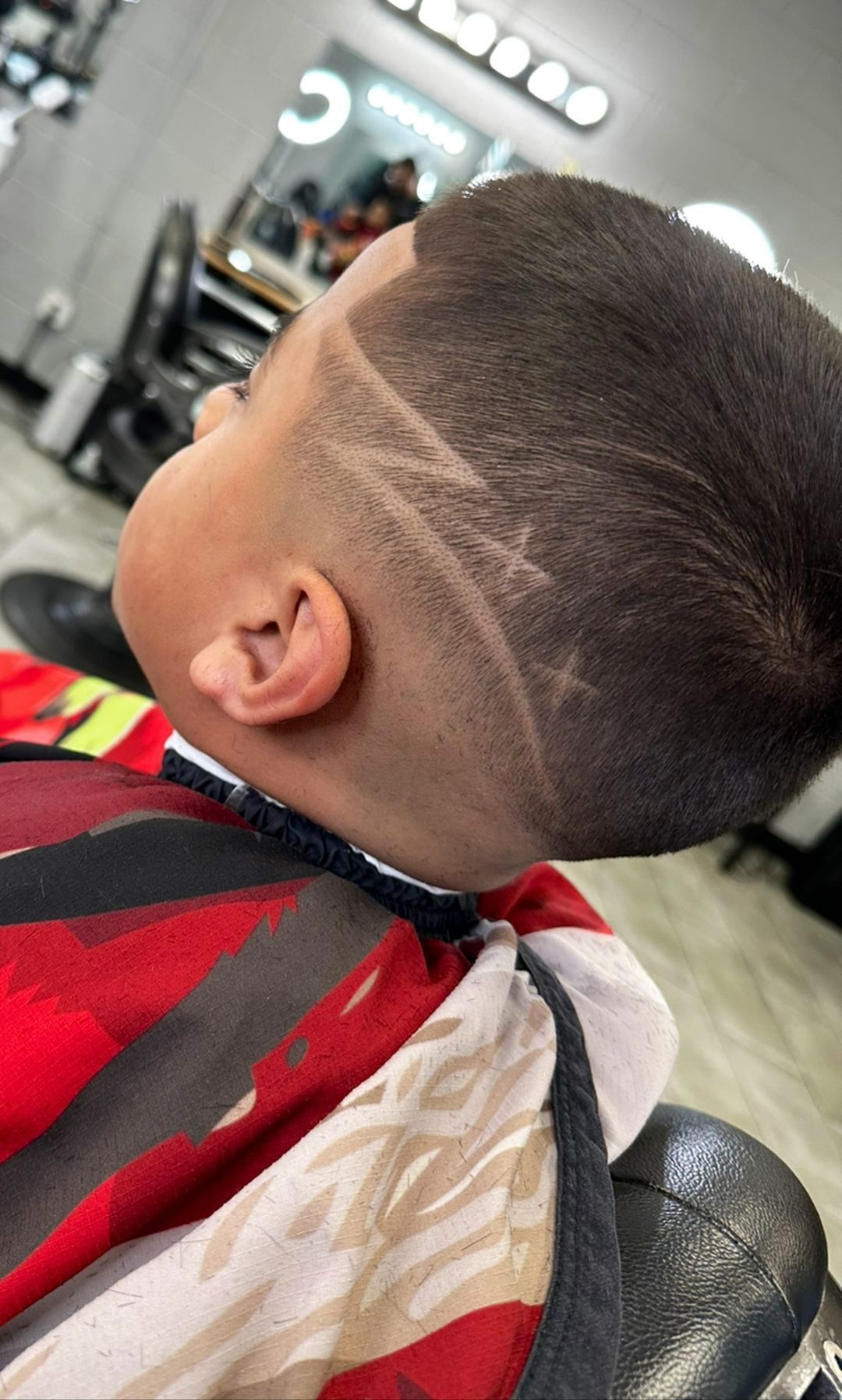 A young boy is getting his hair cut at a barber shop.