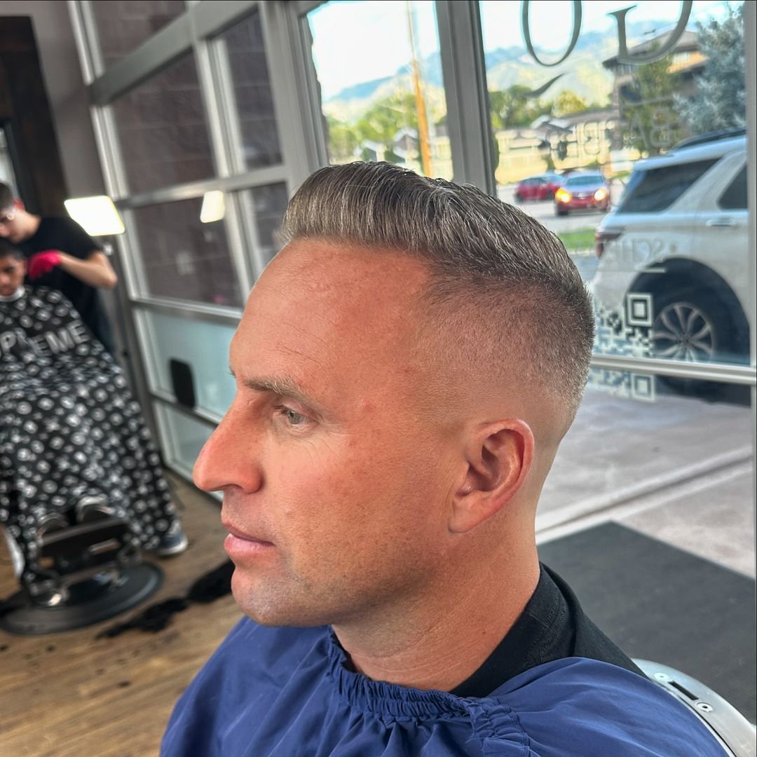 A man is getting his hair cut at a barber shop