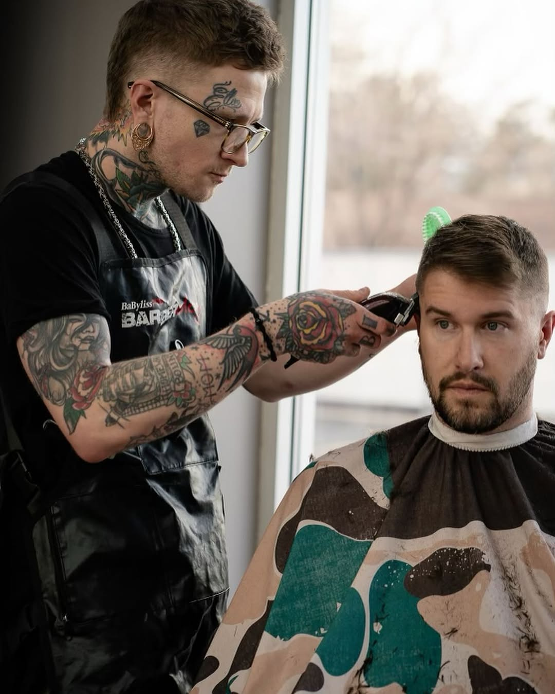 A man is getting his hair cut by a barber in a barber shop.
