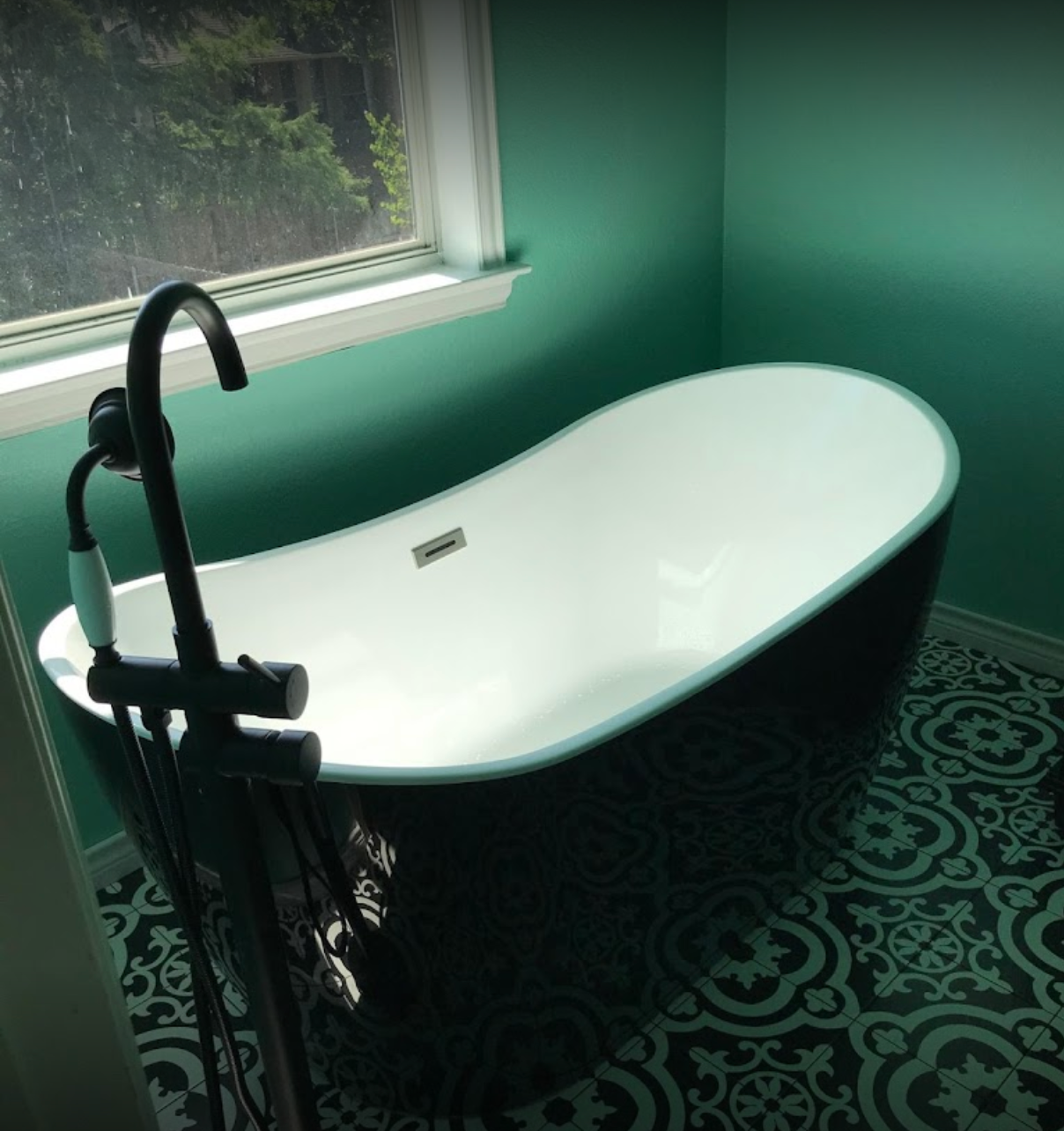 A bathtub in a bathroom next to a window