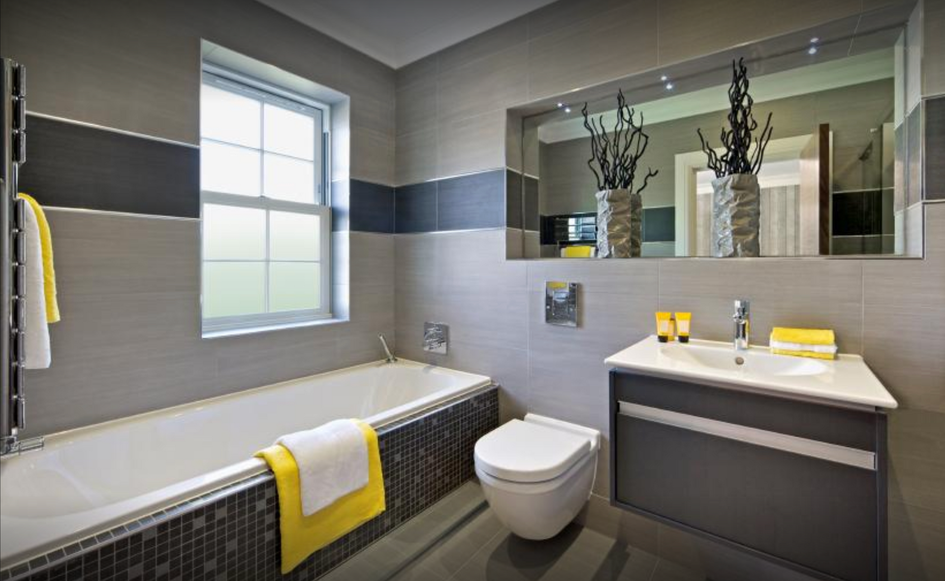 A bathroom with a tub , toilet , sink and mirror