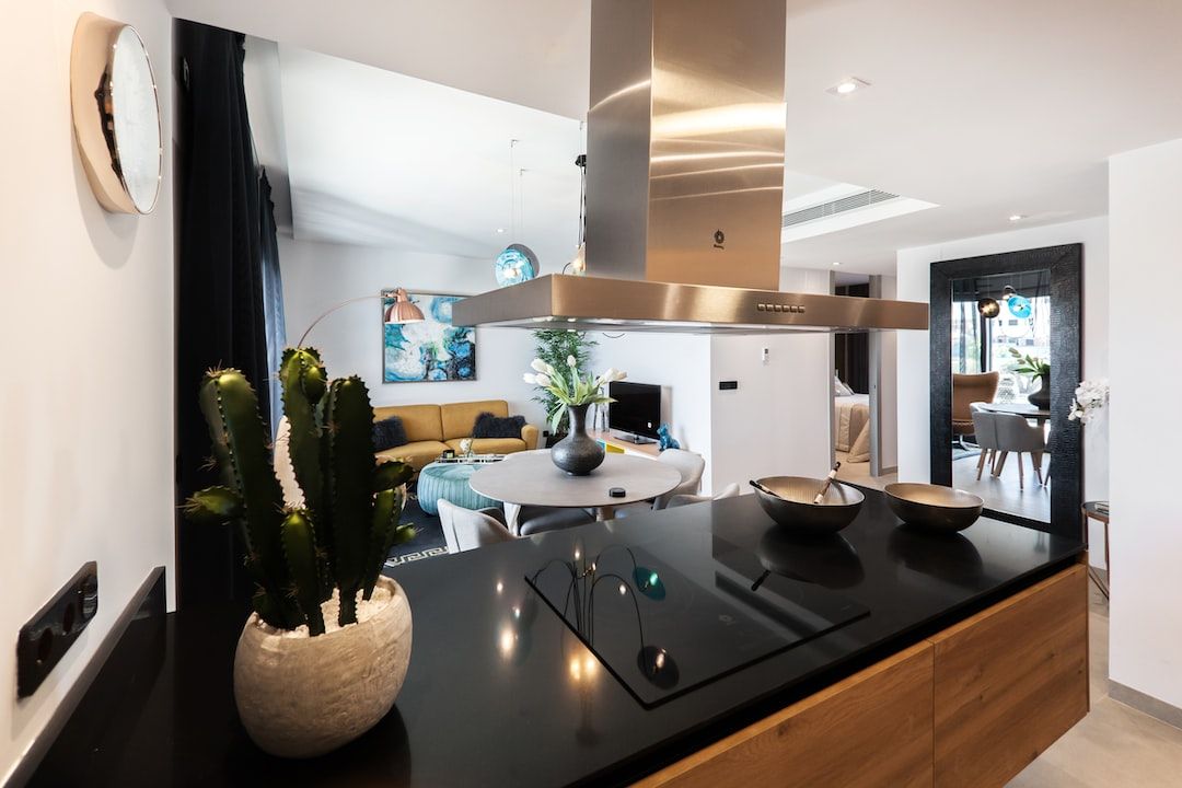 A kitchen with a stove top oven and a stainless steel hood.