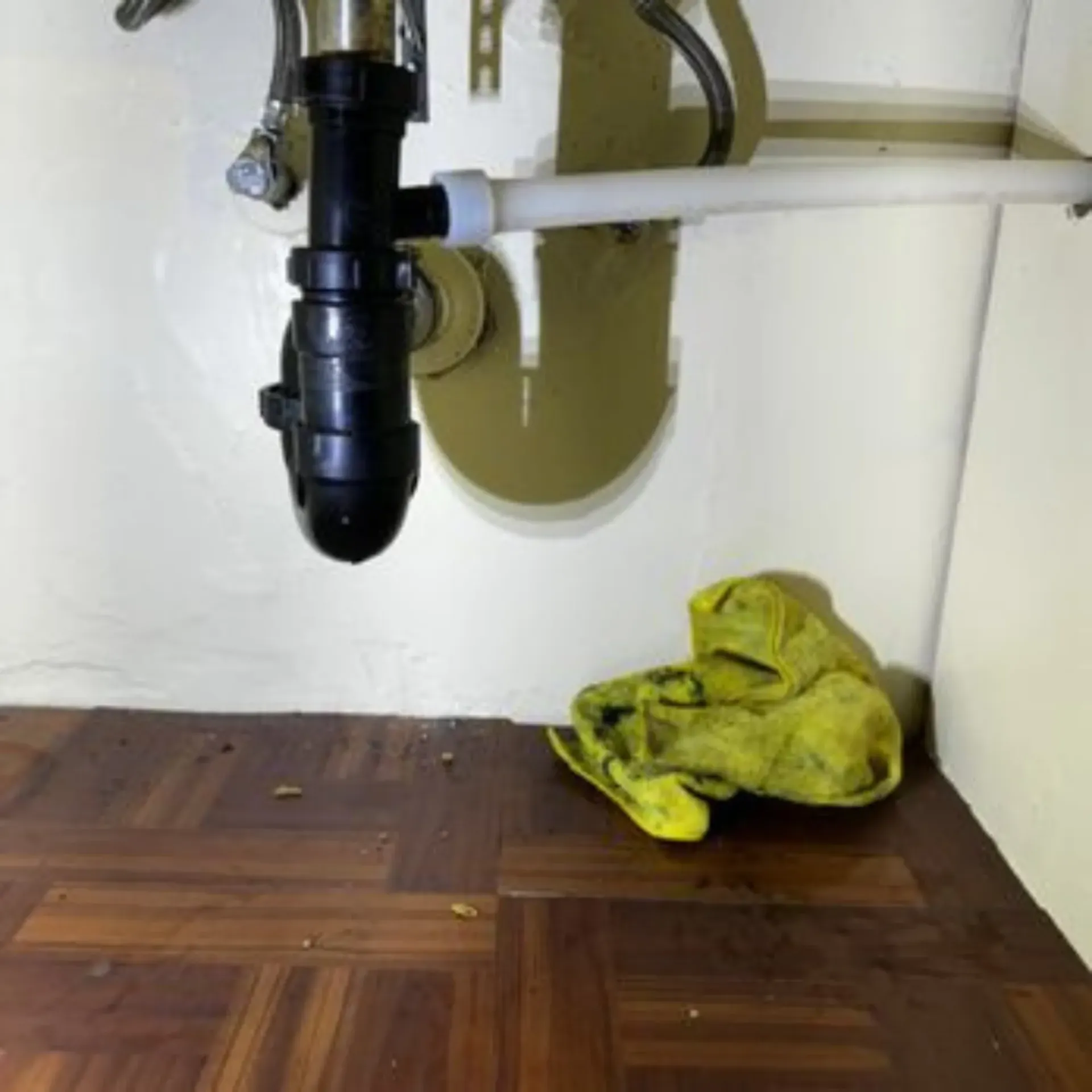 GTZ Plumbing Service LLC - A yellow towel is laying on the floor under a sink