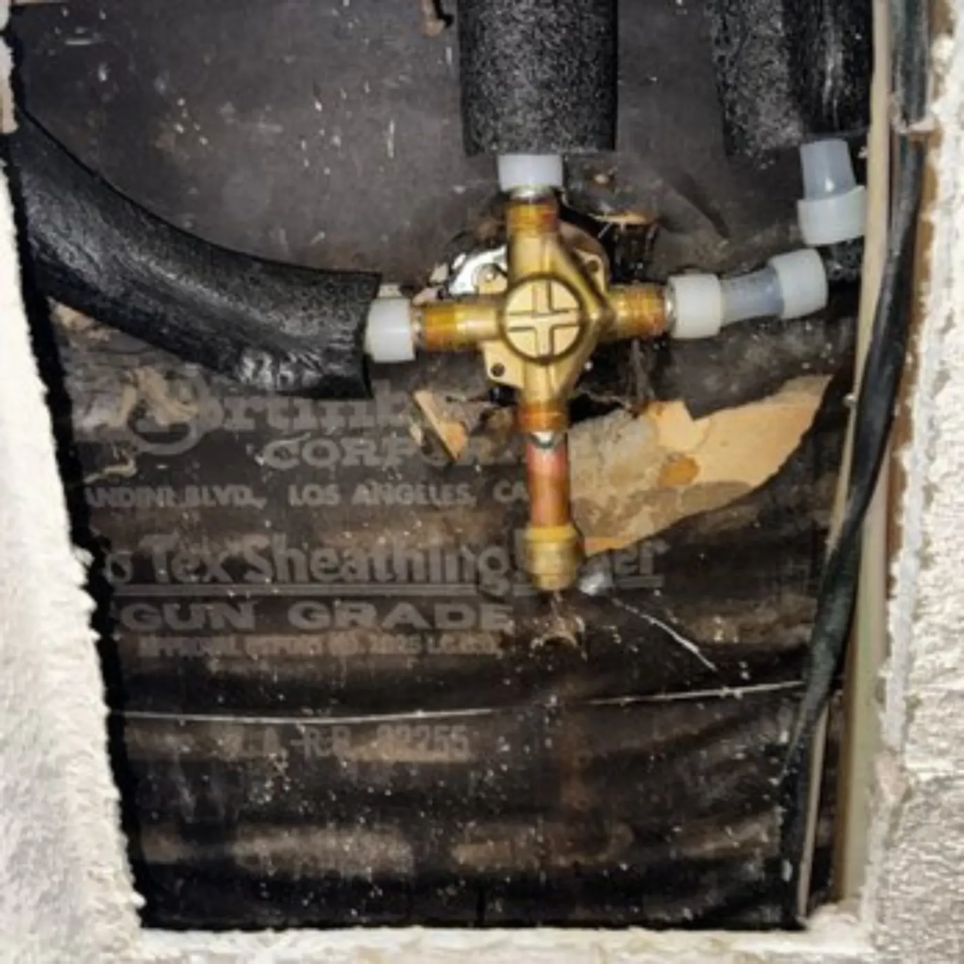 GTZ Plumbing Service LLC - A close up of a valve on a wall that says tek sheathing
