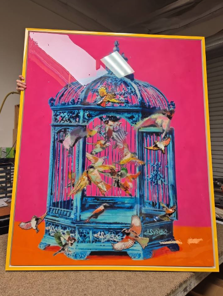 Large framed art piece: turquoise birdcage with colorful birds against pink background.