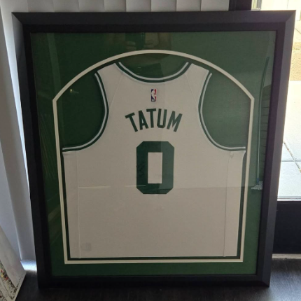 Framed Jayson Tatum Boston Celtics jersey, white with green trim, on a green background.