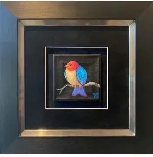 Colorful bird painting on a branch, framed with black and silver; the bird has a blue, orange, and yellow body.