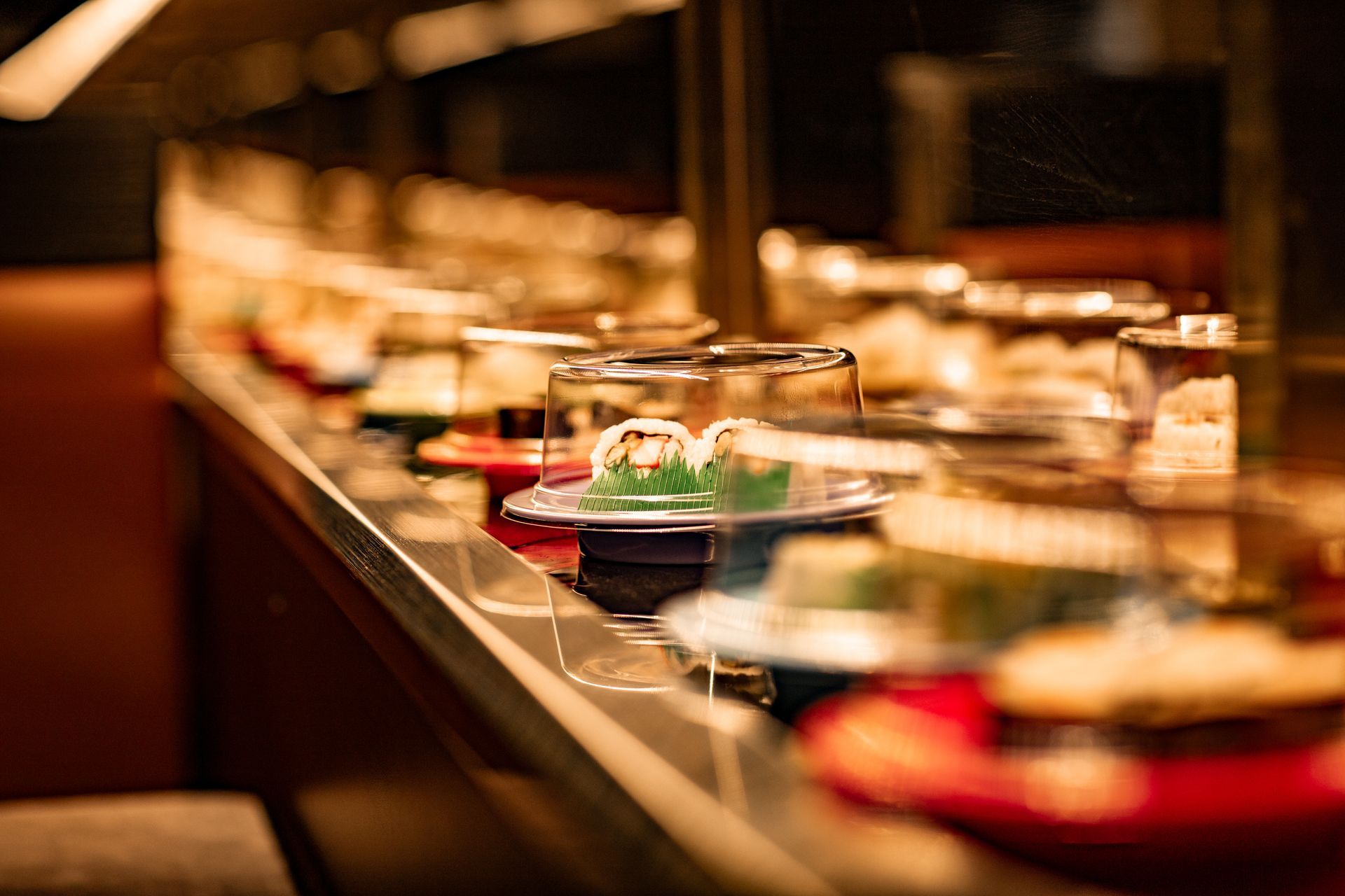 A conveyor belt filled with plates of food in a restaurant.