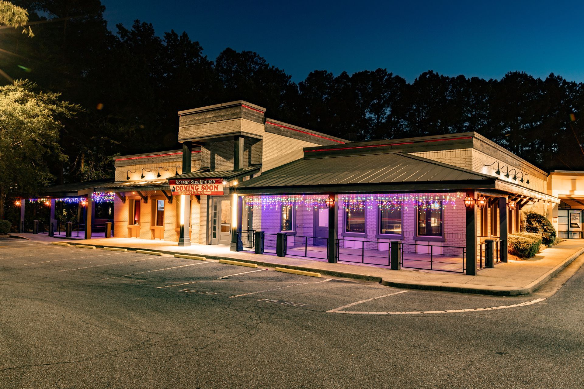 A building with purple lights on it is lit up at night.