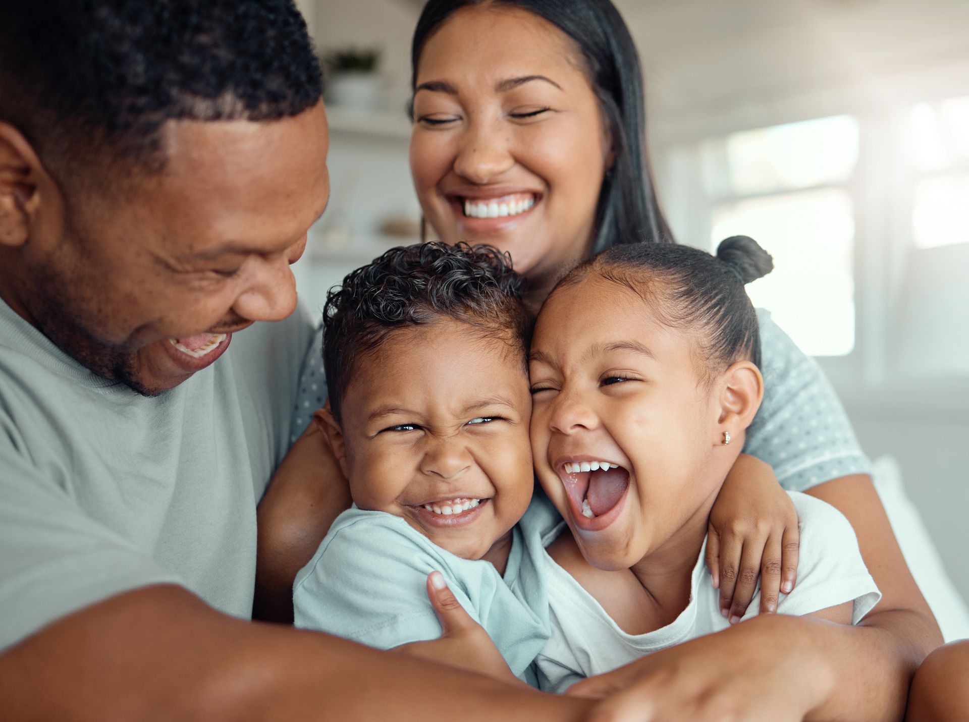 A family is laughing together while sitting on a couch.