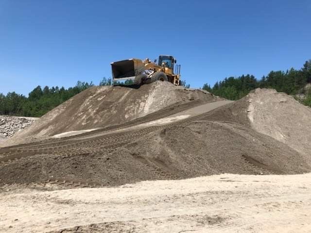 Un bulldozer est posé sur un tas de terre.
