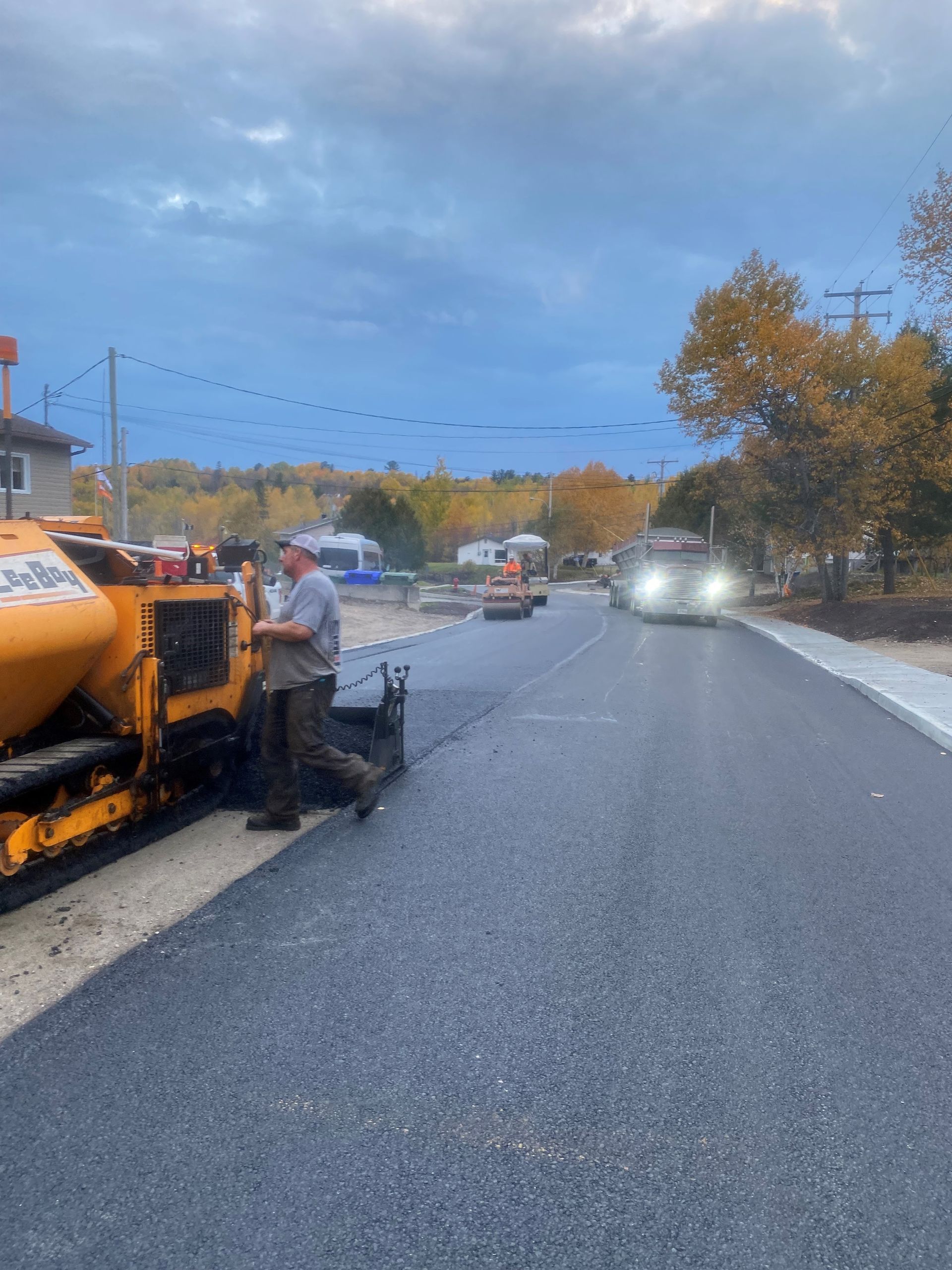 Un homme conduit une machine sur le bord d’une route.