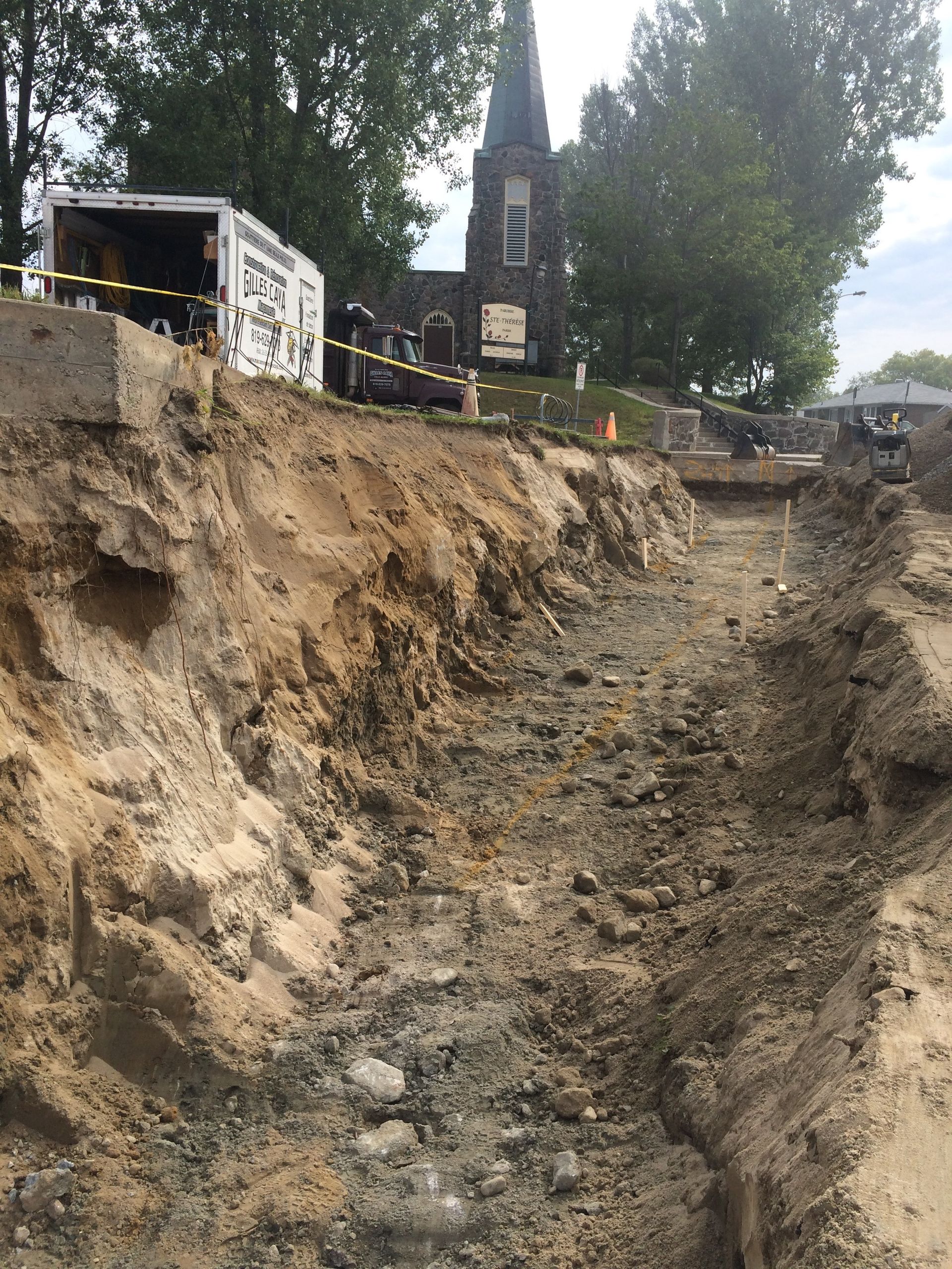 Un gros tas de terre est en train d’être creusé devant une église.