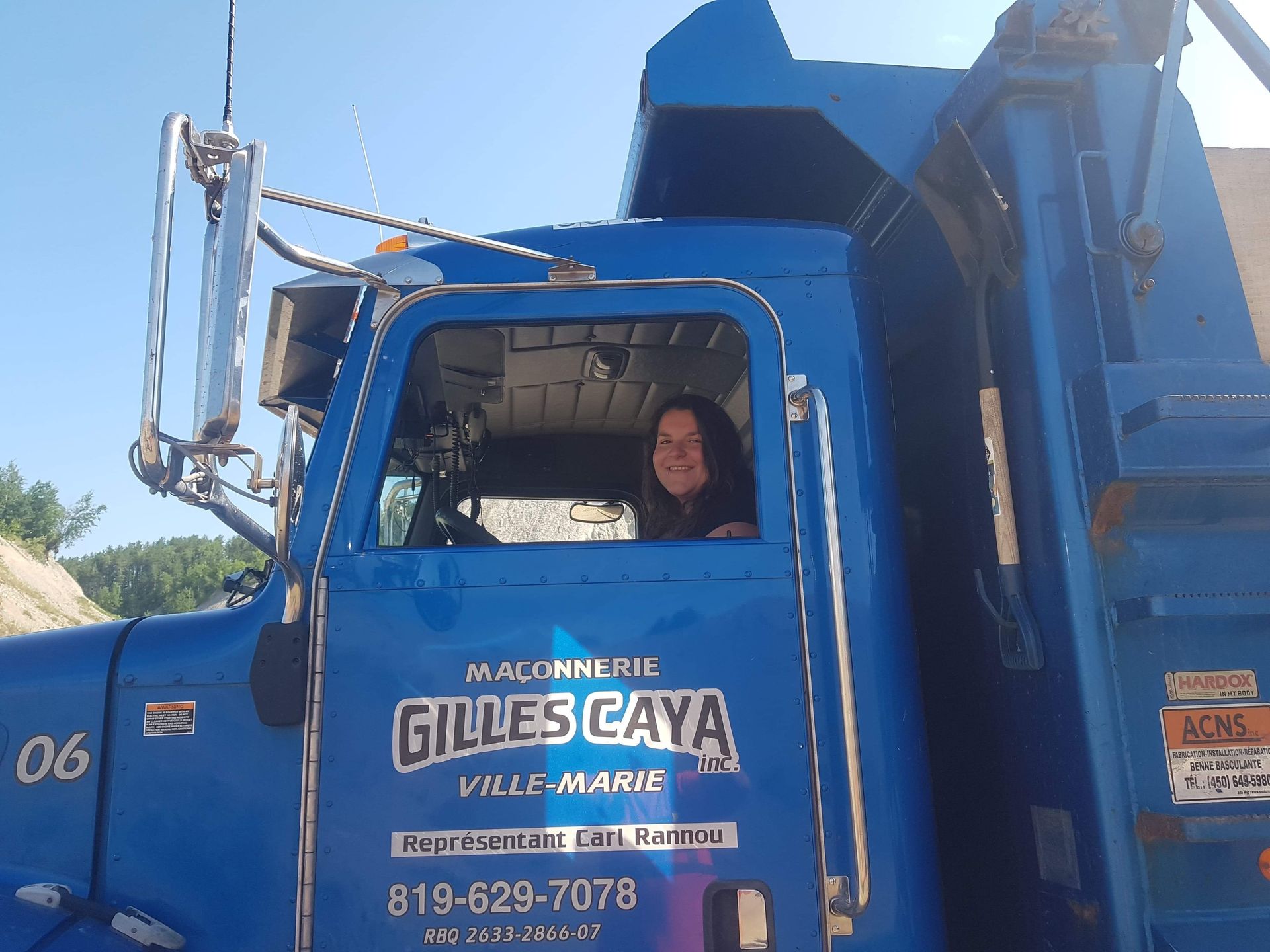 Une femme conduit un camion-benne bleu Gilles Caya