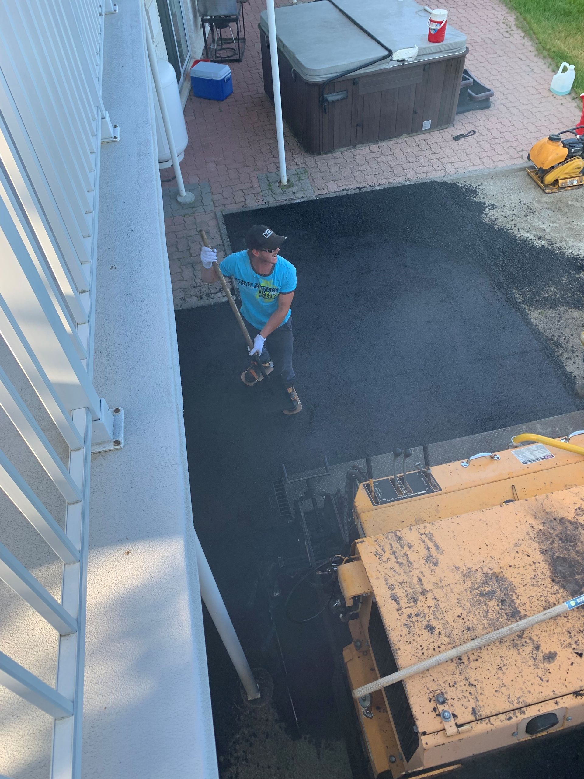 Un homme se tient à côté d’un bulldozer dans une allée.