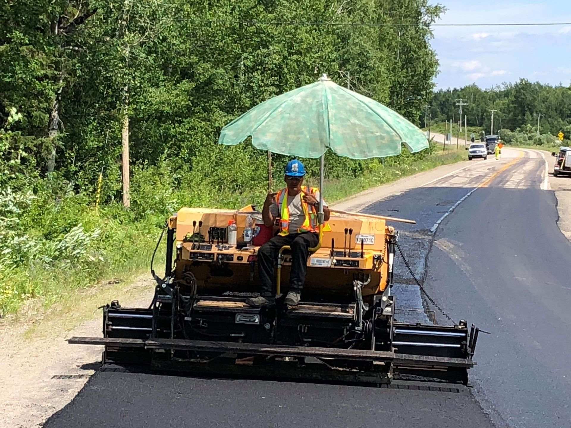 Un homme est assis sur une machine et tient un parapluie.