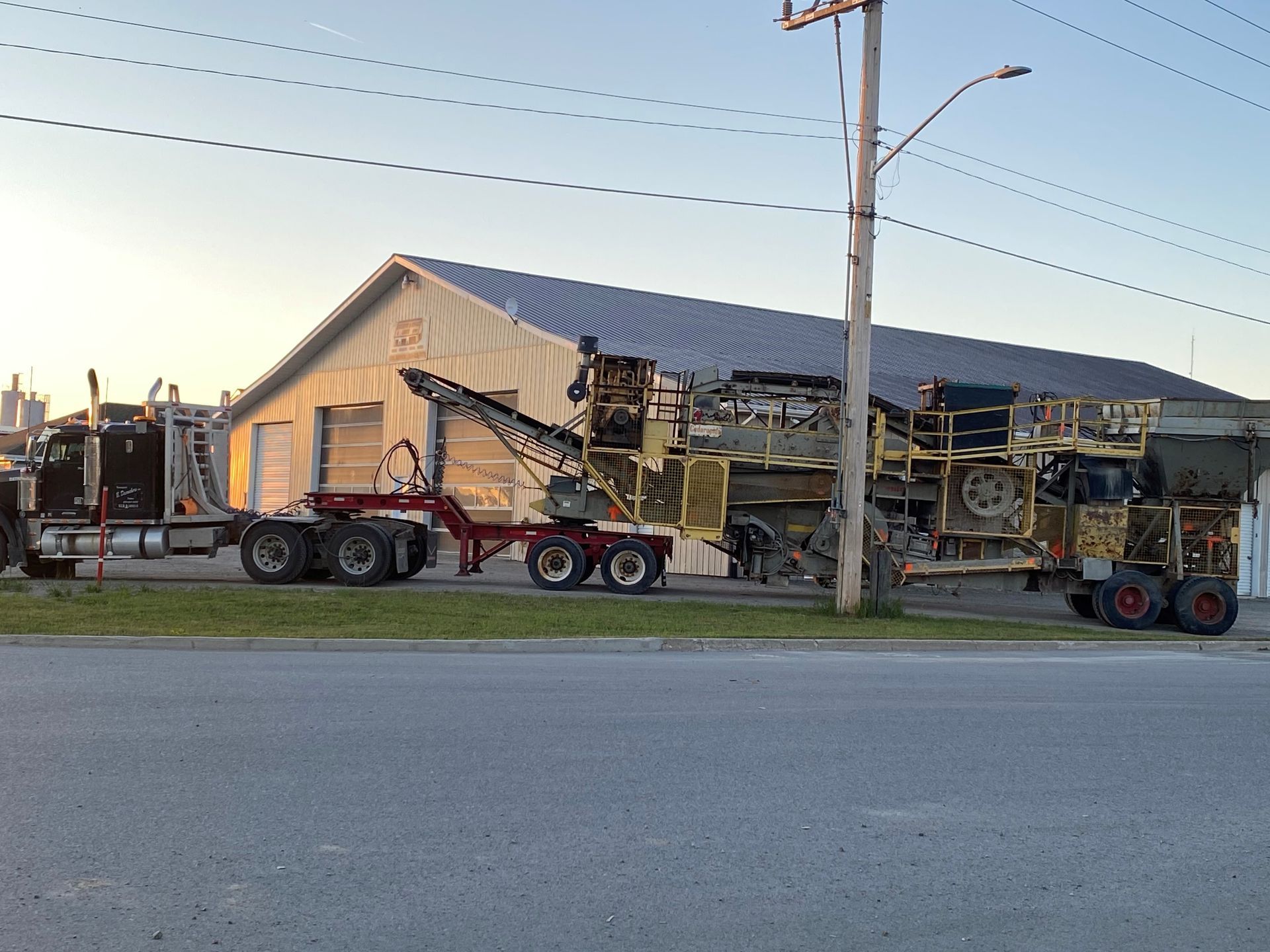 Un camion transporte une grosse machine sur une remorque.