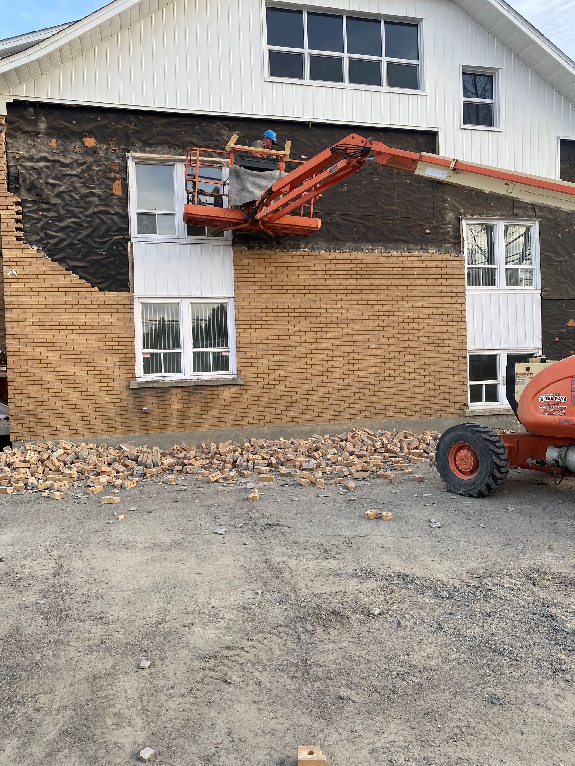 Une grue est utilisée pour retirer le revêtement d une maison.
