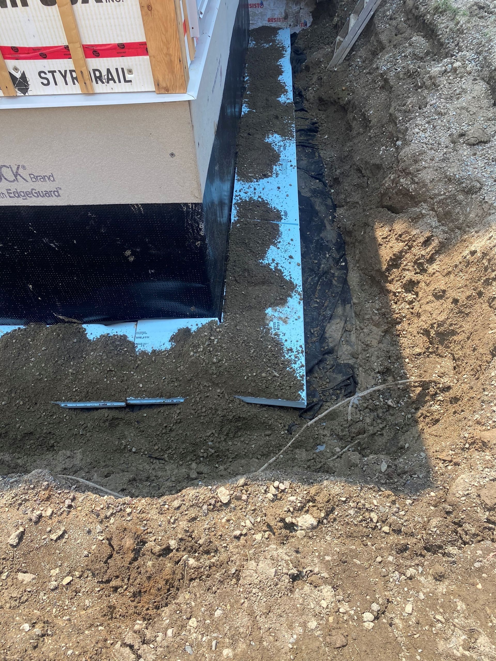 Une boîte est posée au sommet d’un tas de terre dans un trou.