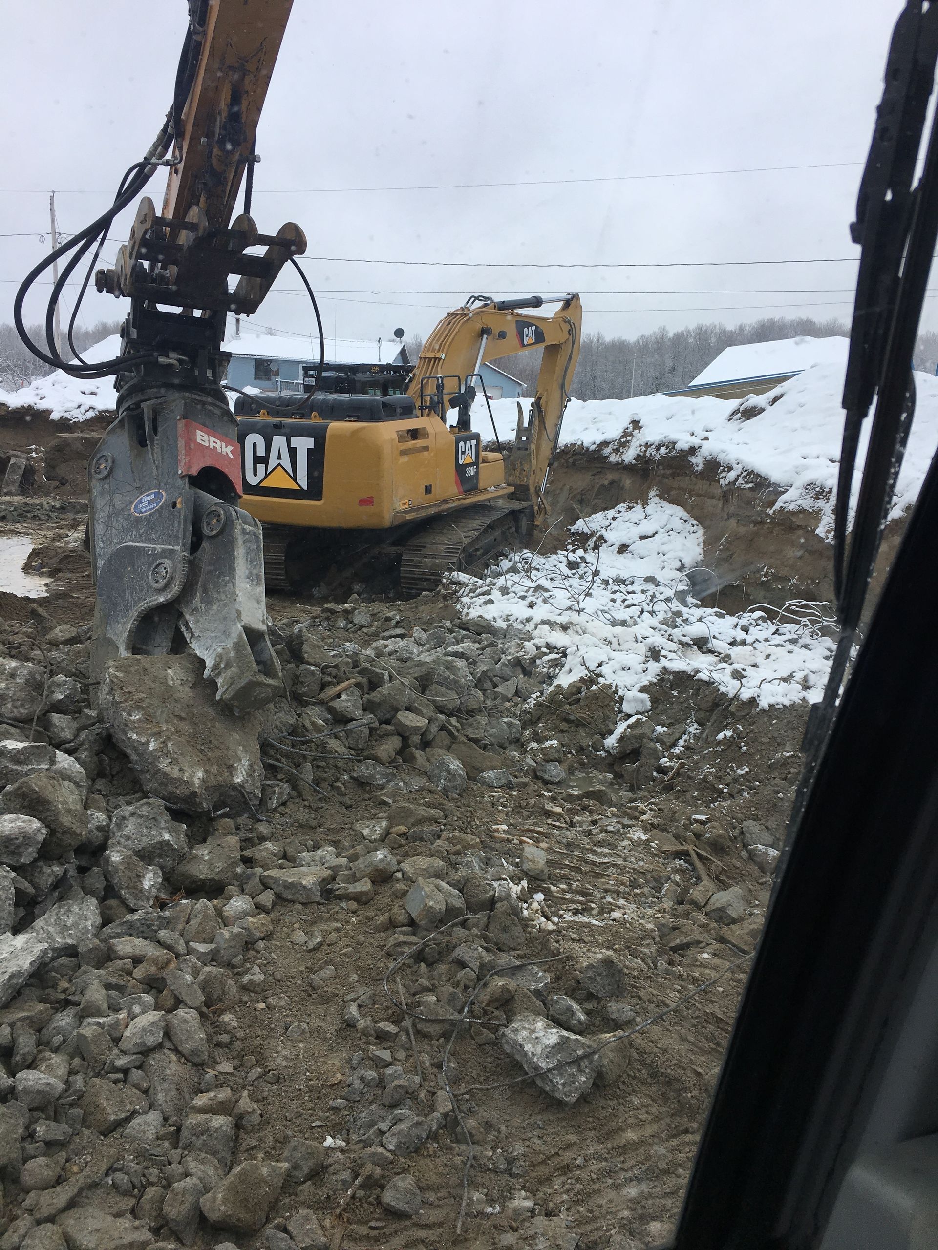 Une excavatrice à chat déplace des roches dans un tas de terre.