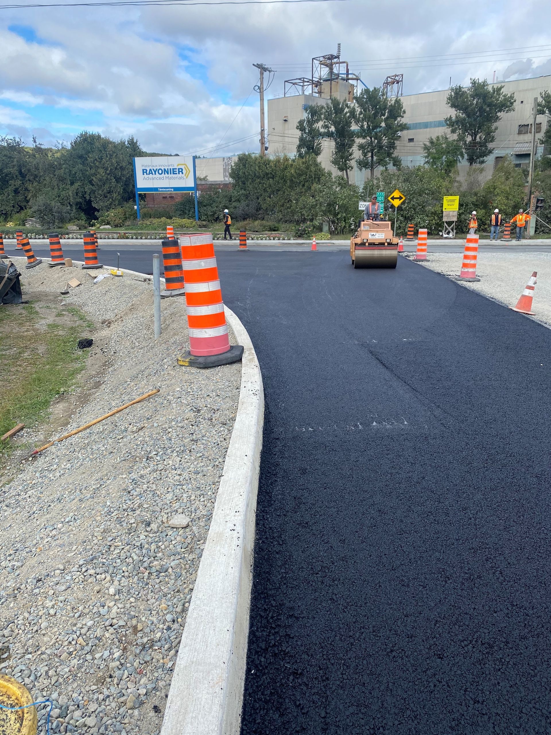 Un rouleau roule de l'asphalte sur une route.