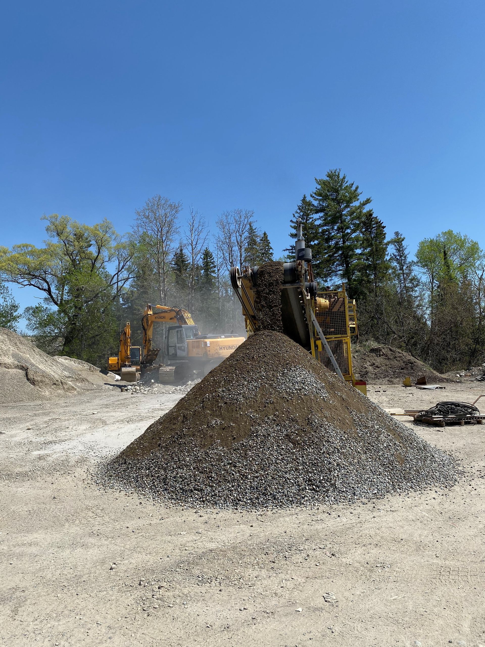 Un tas de gravier se trouve au milieu d’un champ de terre.