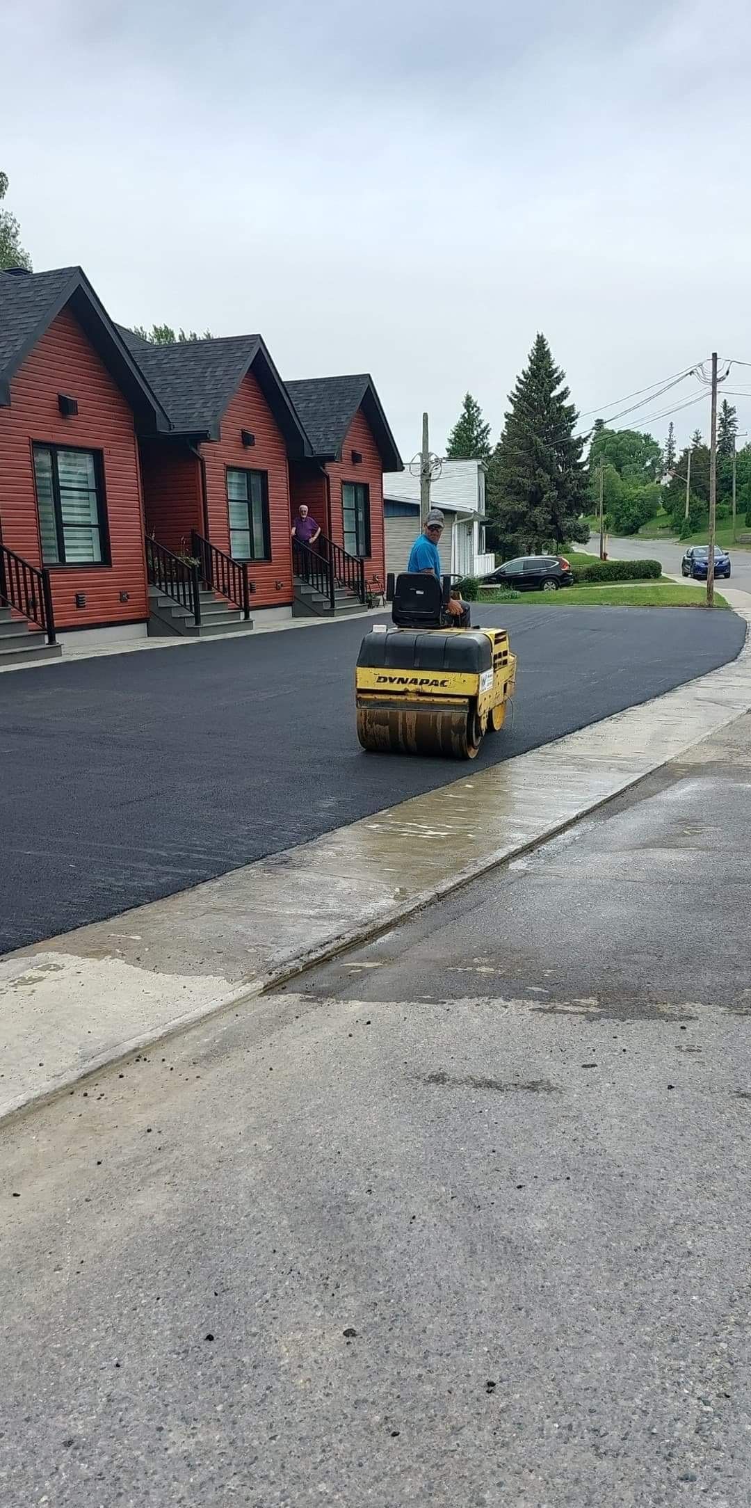 Un rouleau roule de l’asphalte sur le bord d’une route.