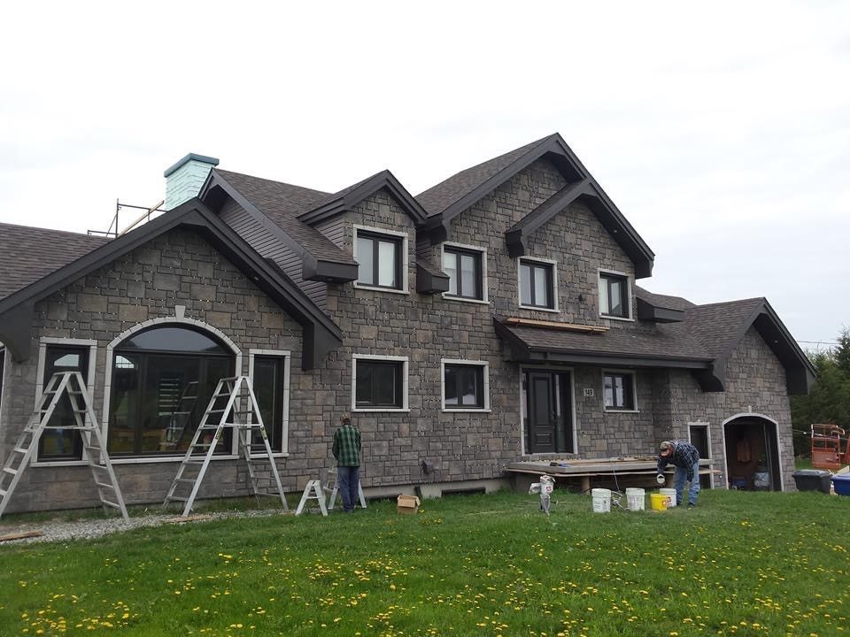 Une grande maison en brique avec une échelle devant elle