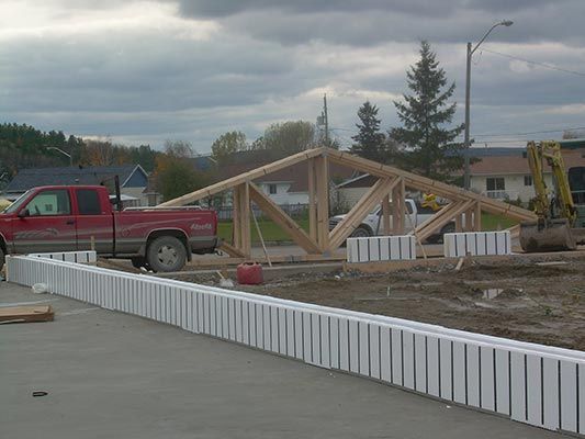 Un camion rouge est garé devant un chantier de construction