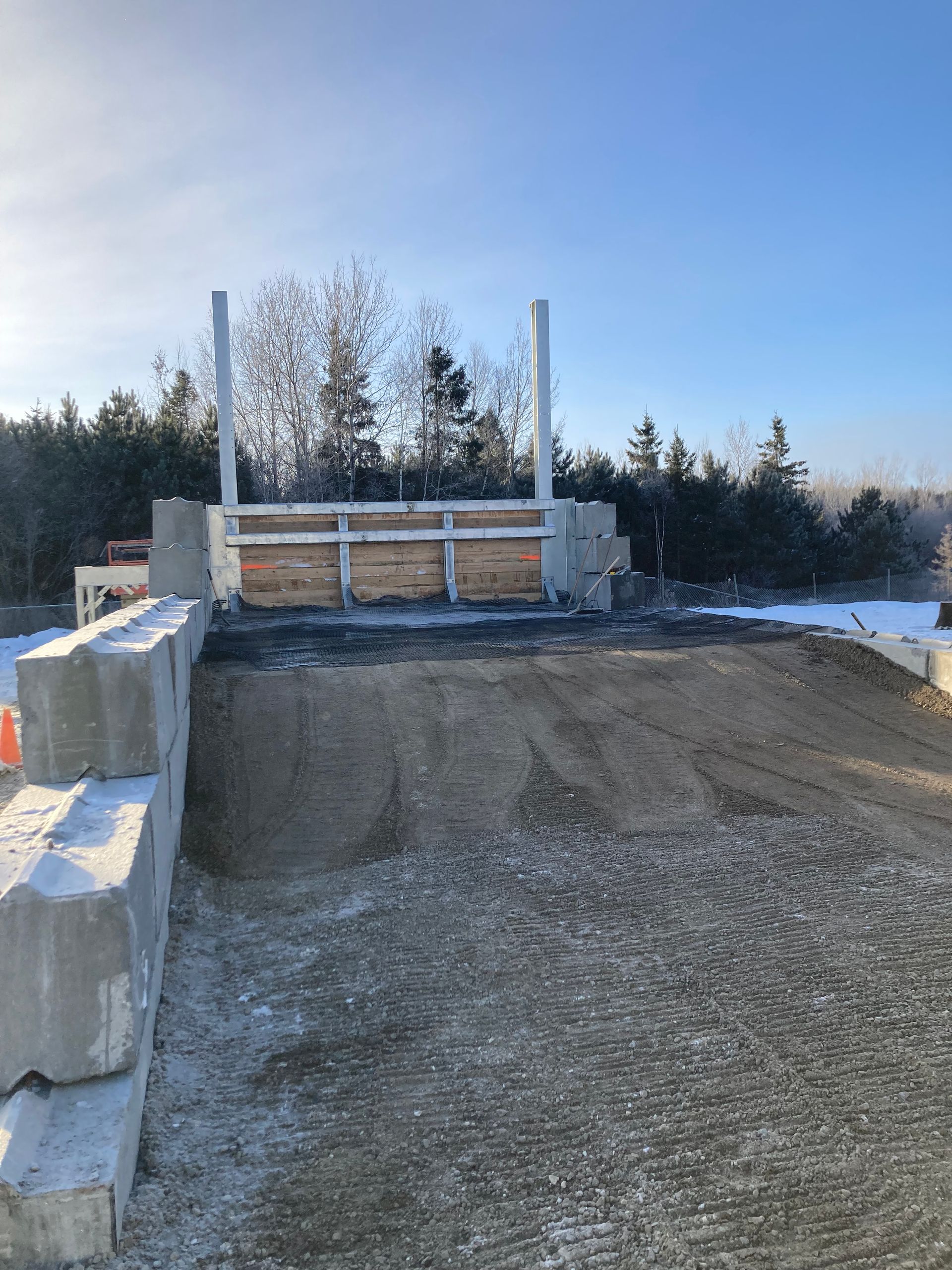 Un chantier de construction avec beaucoup de terre et des arbres en arrière-plan.