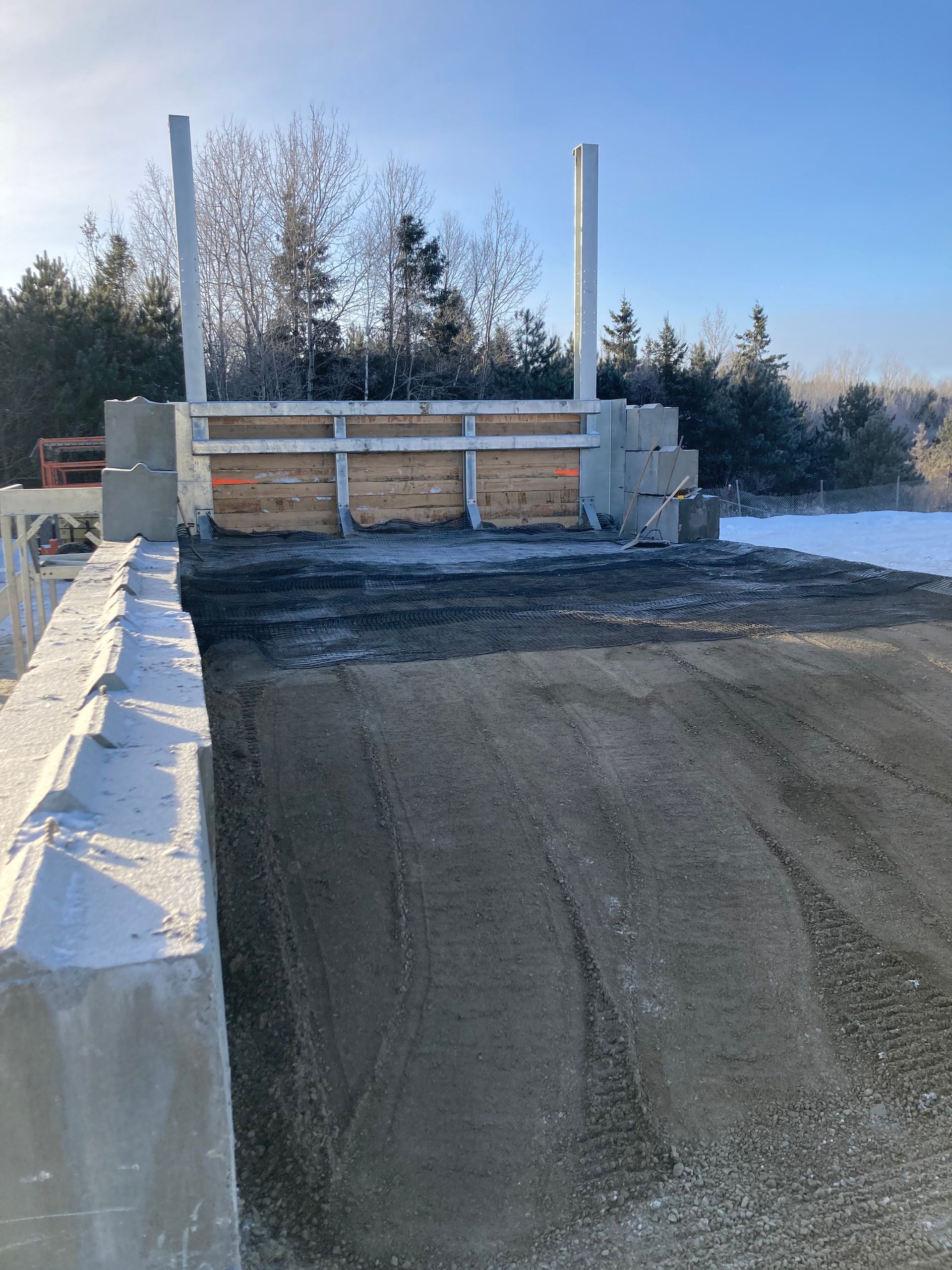 Une grande structure en béton est en construction au milieu d un champ enneigé.