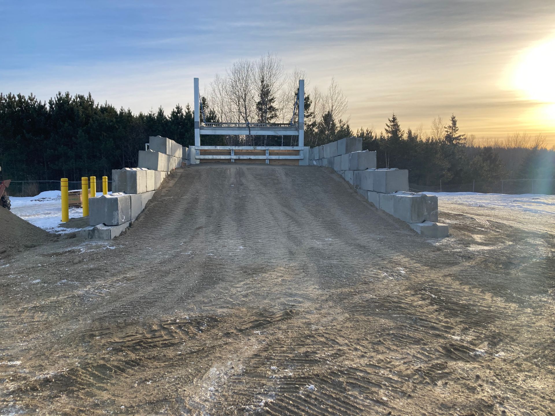Un camion roule sur un chemin de terre à côté d’un tas de blocs de béton.