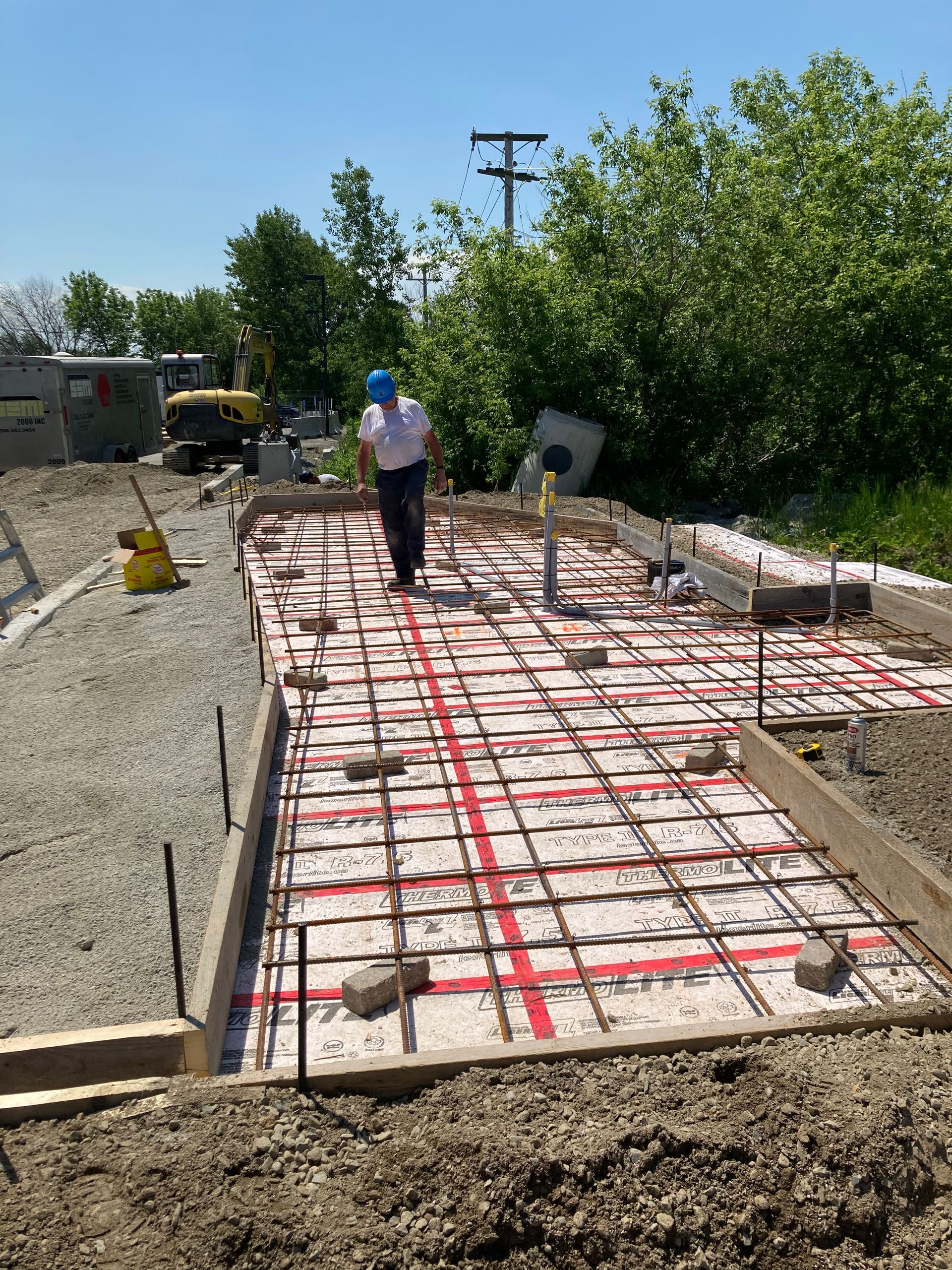 Un homme portant un casque bleu marche sur une dalle de béton.