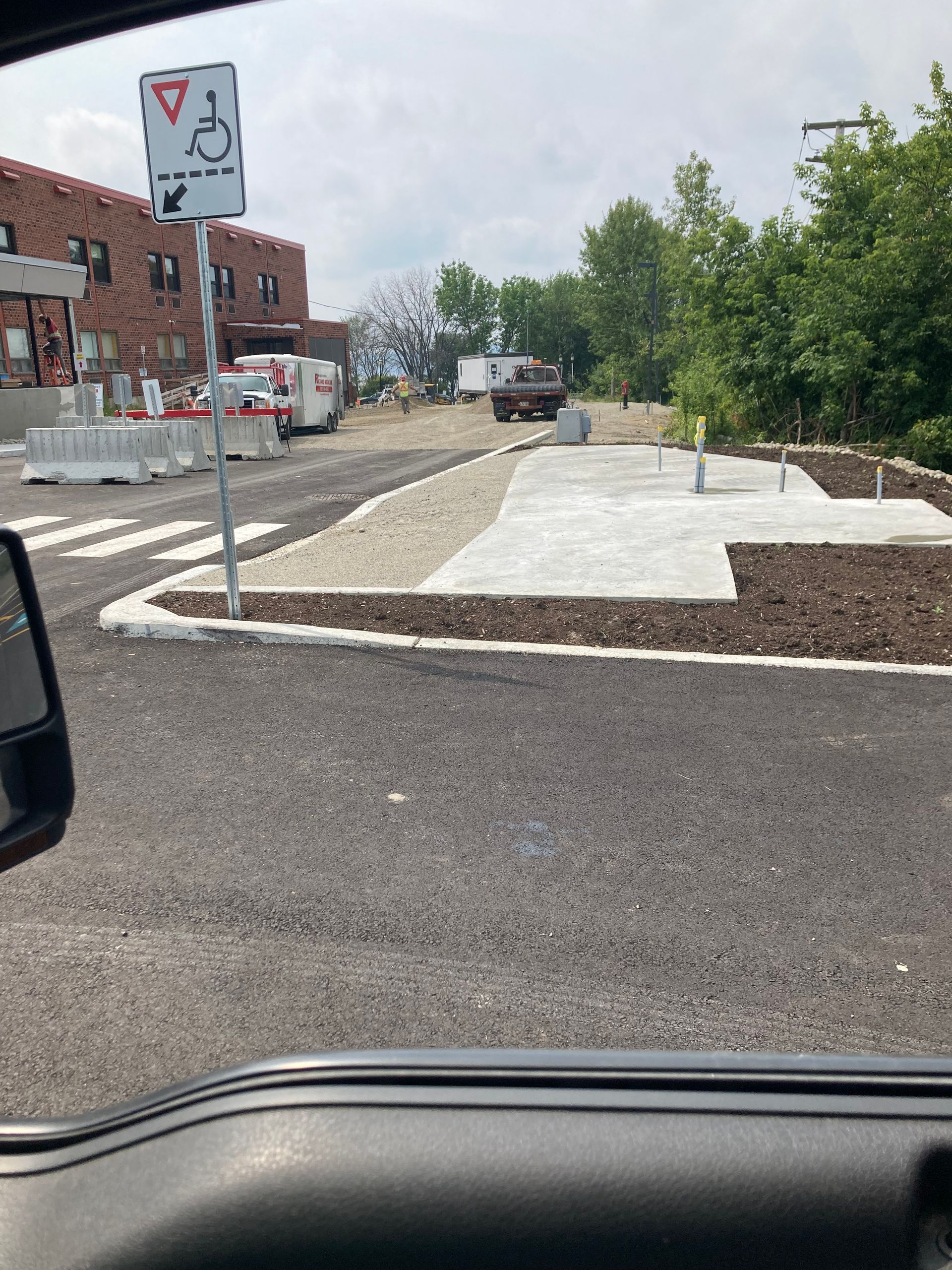 Une voiture roule dans une rue avec un panneau pour personnes handicapées sur le bord de la route.