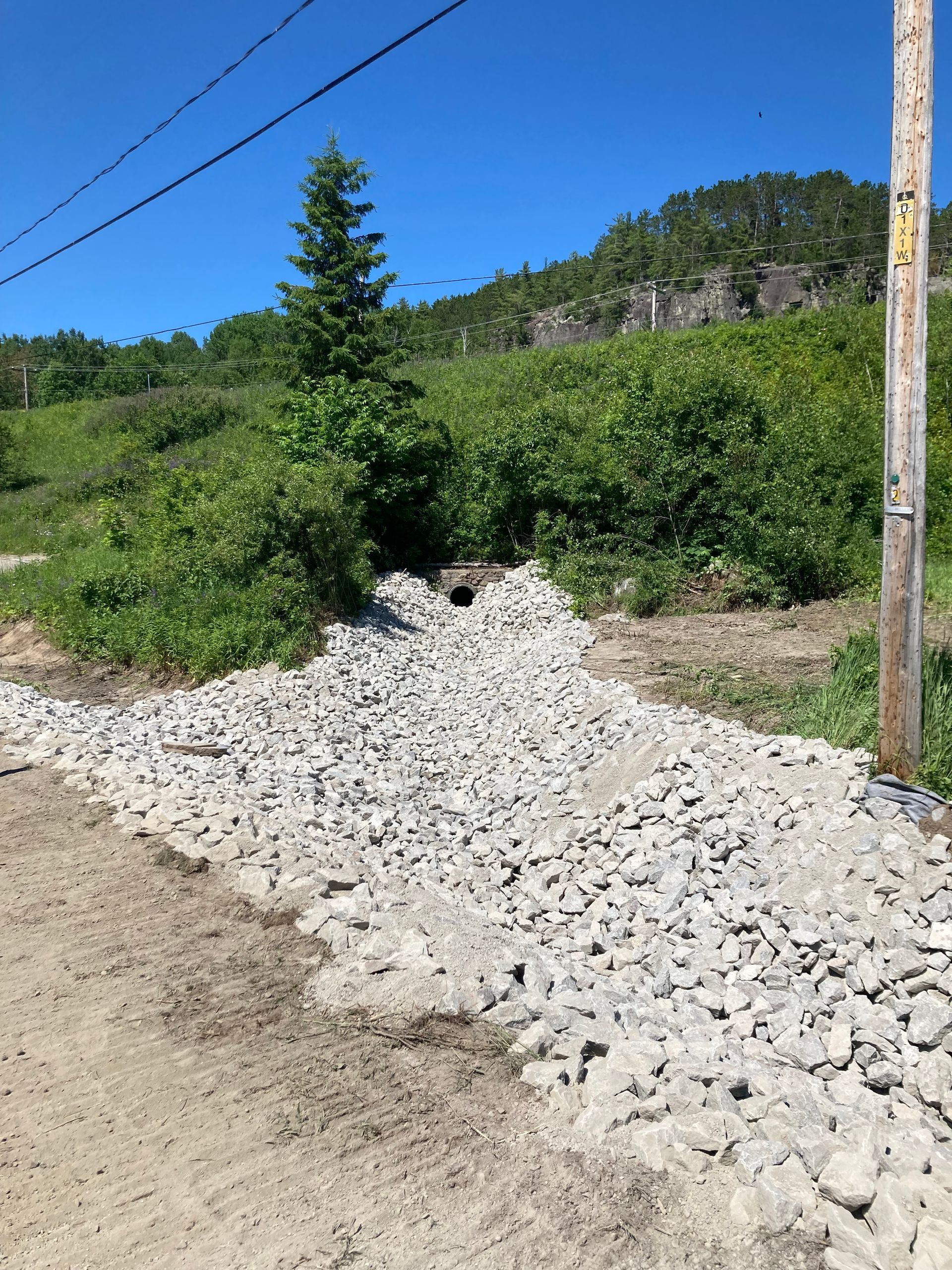 Un tas de gravier se trouve au bord d’un chemin de terre.