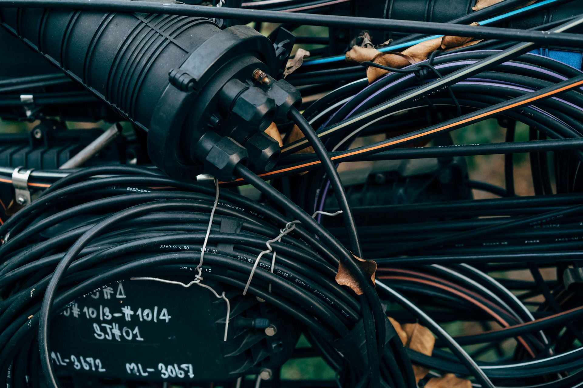 Black cables and connectors of telecommunications equipment outside.