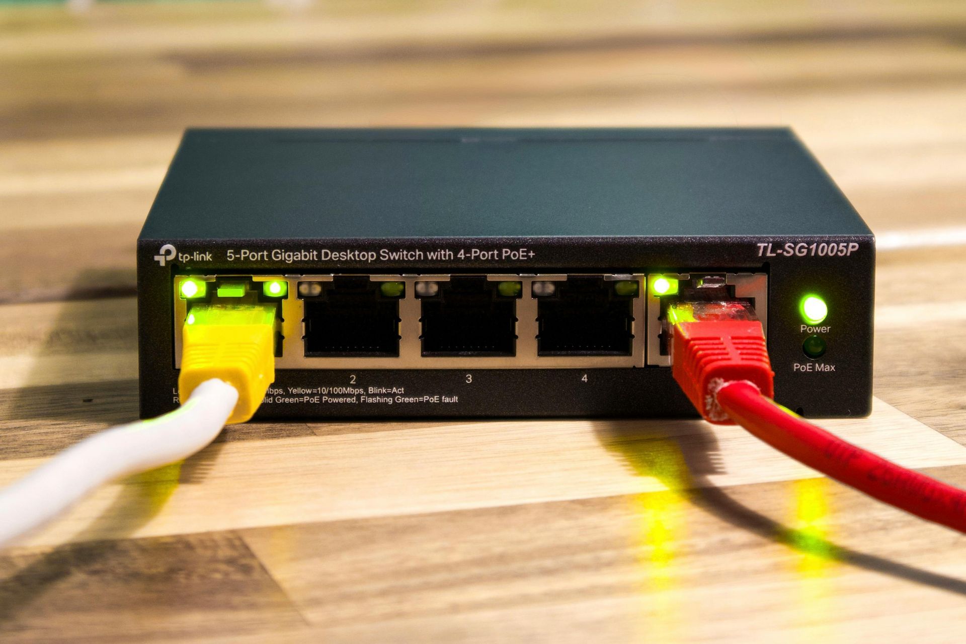 Network switch with yellow and red Ethernet cables plugged in.