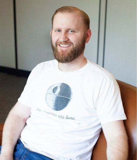A man with a beard is wearing a star wars shirt