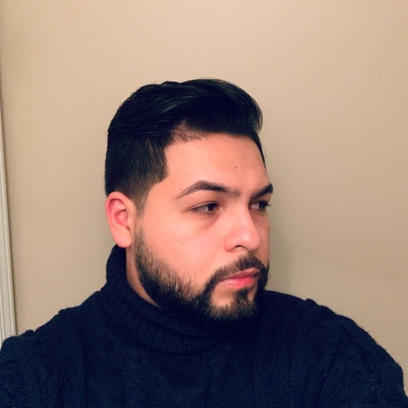A man with a beard wearing a black turtleneck sweater