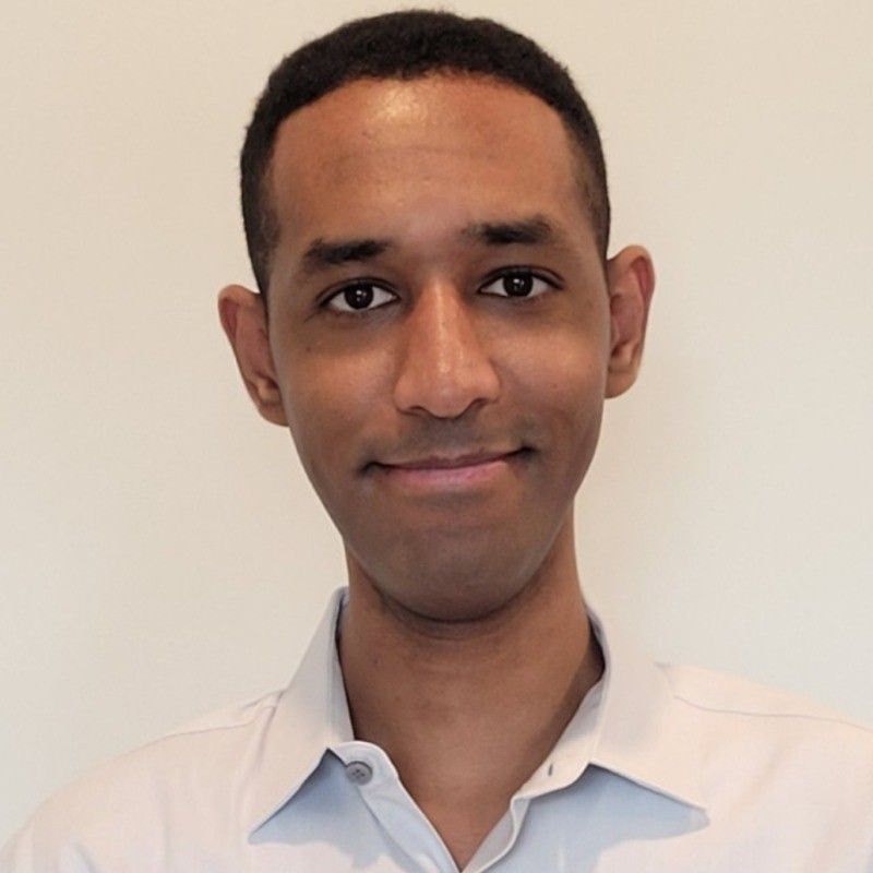 A man in a white shirt is smiling for the camera
